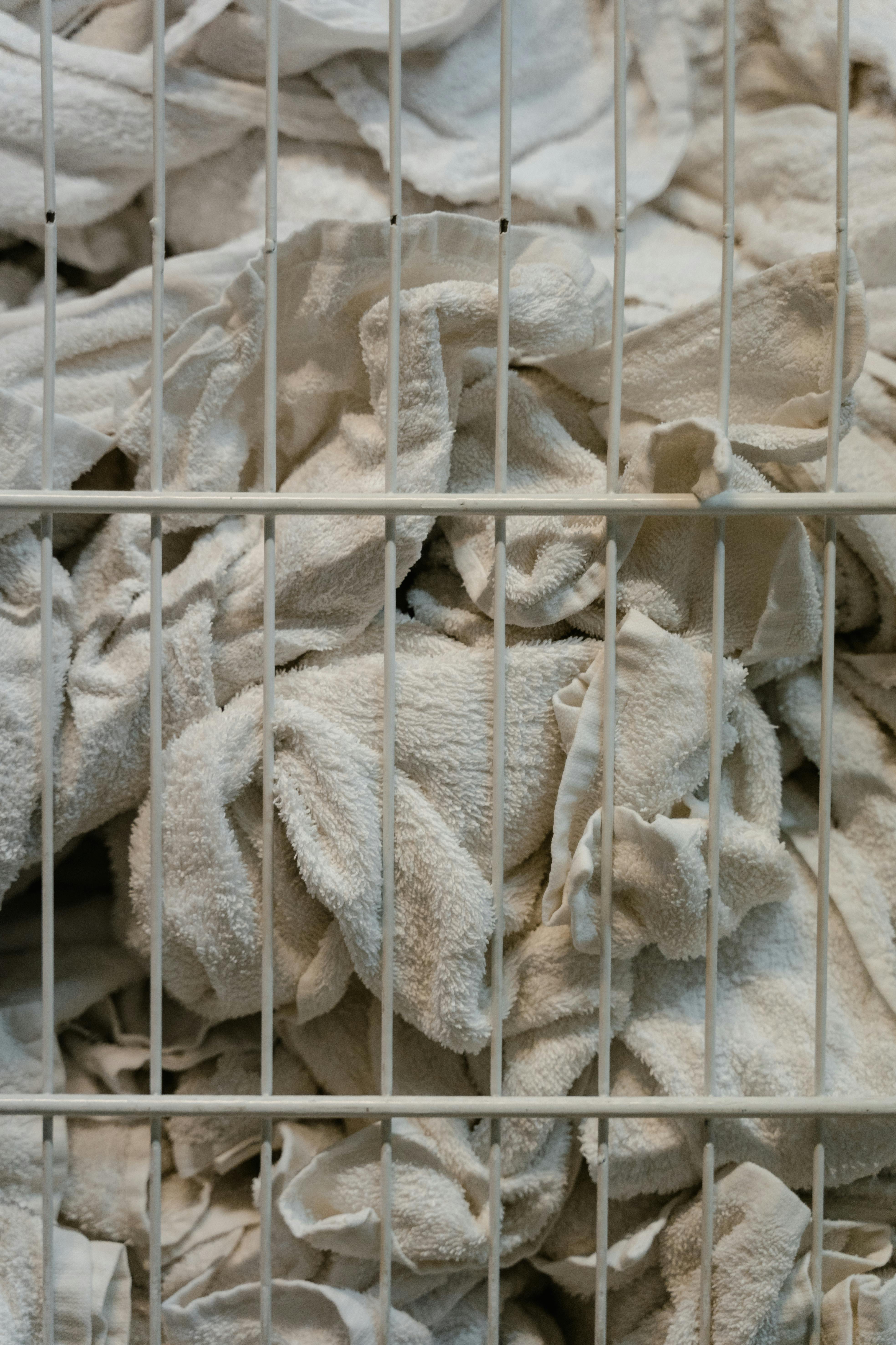 Close-up of white towels in a basket, highlighting textures and industrial setting.